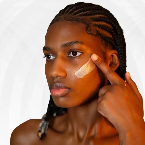 Mulher de pele negra aplicando HAMI Creme Hidratante da Nutri Bu Alma no rosto.