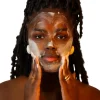 Mulher de pele negra lavando o rosto com espuma da FRESKINHA Mousse de Limpeza da Nutri Bu Alma.